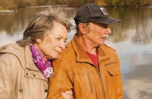 Ehepaar Kollrich geht am Wasser spazieren, herbstliche Stimmung, sie legt den Kopf auf seine Schulter